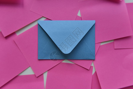 粉红色贴纸中间的选择性焦点蓝色信封背景图片