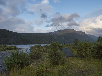 美丽的拉普兰野生自然景观中的小绿色帐篷 拥有蓝河 Teusajaure 湖 白桦树和山脉 瑞典北部的夏天在远足径 蓝天戏剧性的云灌木丛高清图片素材