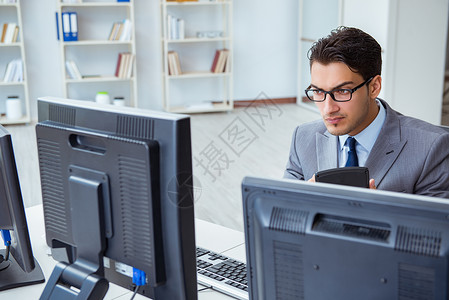 坐在许多屏幕前的商界人士 操作员 计算器 戏法 监控图片