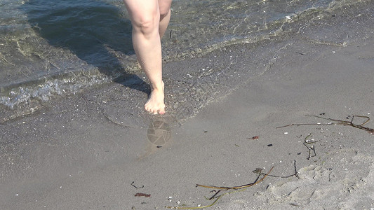 年轻女性在浅水中走在黄海上b 太阳 脚印 脚幸福高清图片素材