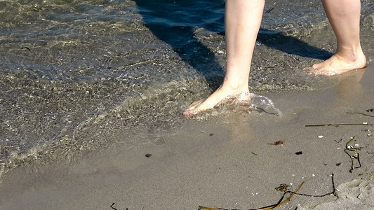 年轻女性在浅水中走在黄海上b 蓝色的 旅游 脚步支撑高清图片素材