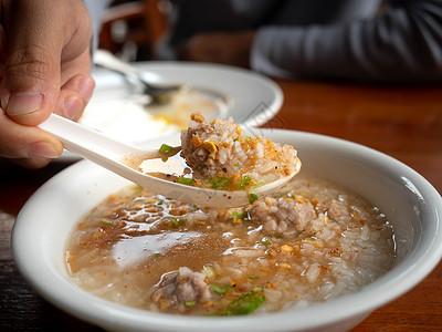 用勺子把煮饭的大米 和汤匙一起拿来稀饭高清图片素材