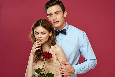 粉红色孤立背景下手捧玫瑰的恋人拥抱情感幸福浪漫的感觉 礼物 美丽的周年纪念日高清图片素材