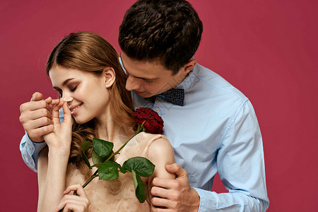 粉红色孤立背景下手捧玫瑰的恋人拥抱情感幸福浪漫的感觉 快乐的 庆典展示高清图片素材