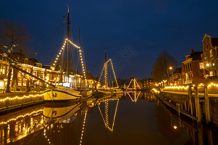 在荷兰Dokkum的港口装饰传统船只 晚上在圣诞节晚礼节举行背景图片