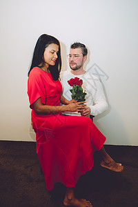 情人节快乐的一对夫妻 年中亚洲女人 与有红玫瑰和情书的cauusian男子 礼物 美丽的庆典高清图片素材