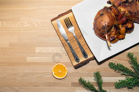 木制背景的烤鹅和苹果 从上到下 有树枝和橙子的圣诞菜菜单高清图片素材