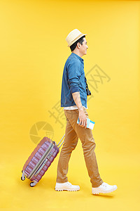 带旅行袋和摄影机的快乐男性游客 准备出行 在黄色上隔离 旅游 假期背景图片