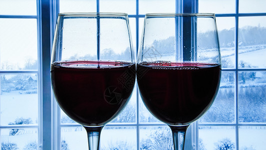 背景窗里的两杯红酒 雪山 窗外的冬日景色 复制空间举起高清图片素材