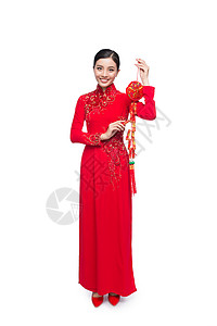 一位美丽的亚洲妇女穿着传统节服Ao Dai Tet节日 月亮新年 全文指幸运和幸福 女性 红色的背景图片