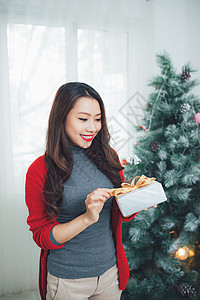 圣诞节 亚裔漂亮女人 拿着礼物庆祝新年背景图片