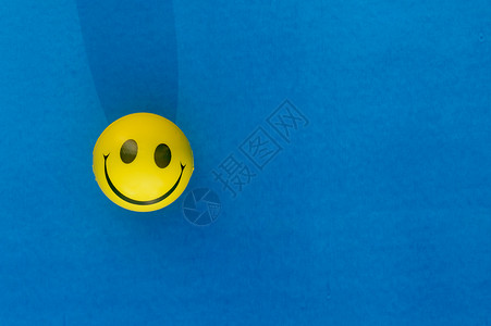 拟人化脸在蓝色背景上隔离的挤压球或压力球的拟人化笑脸表情 桌面视图 特写 幸福的微笑背景概念 商业 塑料背景