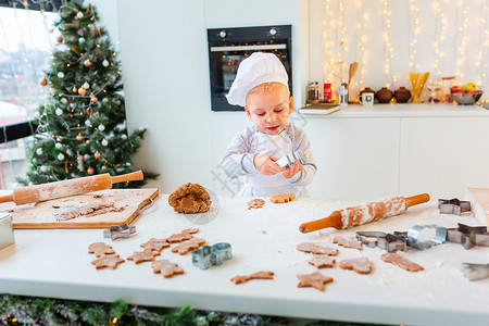 可爱的小男孩做姜饼 切饼干的姜面包面团 曲奇饼高清图片