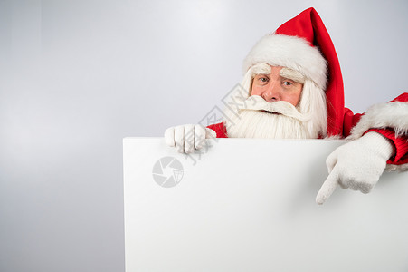 圣诞老人指向一个空空的白色空间 为圣诞节提供促销 床单 新年背景图片