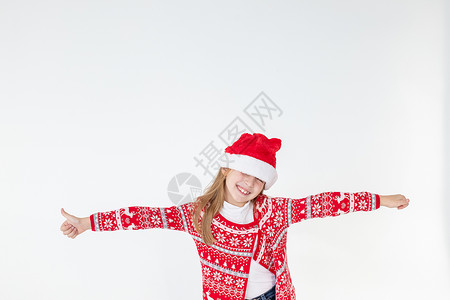 可爱有趣的圣诞老人的帮手在白色背景上跳舞 圣诞假期概念 新年庆祝活动 有趣的婴儿女孩戴着红色圣诞帽庆祝圣诞节 玩得开心 2021惊喜高清图片素材