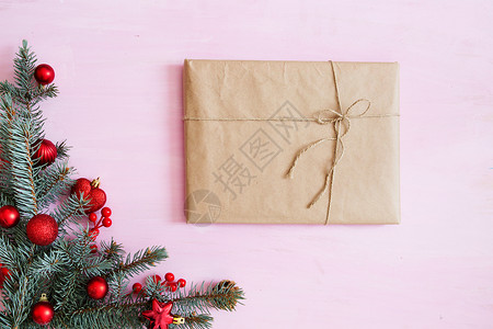 带有礼品盒 fir-tree树枝和角落中红色圣诞节装饰品的粉红木木圣诞背景 框架 从上方查看背景