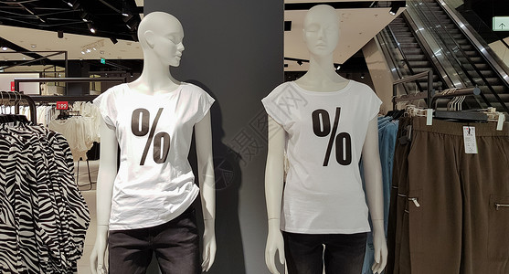 曼纳金人穿着白色T恤衫 在购物中心买东西时有百分位销售牌 宣传 广告 购物和黑色周五概念 背景上装饰背景