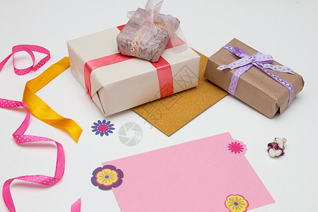 拿卡片小熊白色背景粉色卡片上有亮色丝带和蝴蝶结的礼盒 装饰用小熊 复制空间 顶视图 生日 感恩节 假期 新年 圣诞节 平躺 纸背景