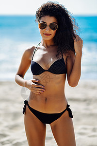 阿拉伯女性在泳衣上穿着美丽的身体 在海滩上戴着飞行墨镜发型高清图片素材