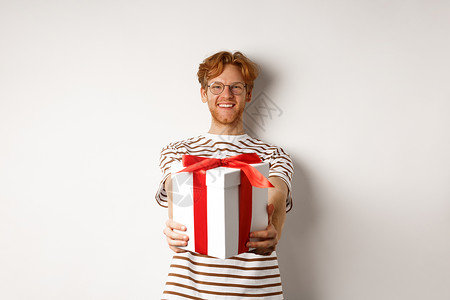 白日情人节和节假日概念 快乐的红发男子微笑 给你礼物盒 与生日祝寿 站在白背景上站立 男朋友 胡须背景图片