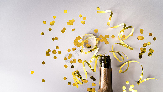 金箔纸螺旋飘带带有金色五彩纸屑飘带白色背景的香槟瓶背景