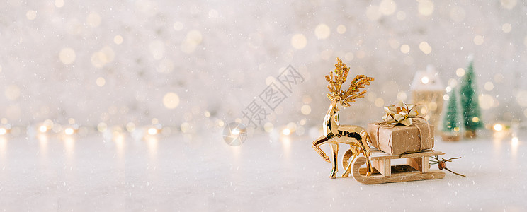雪橇上礼物金鹿在白色背景的玩具木雪橇上拖着天然圣诞礼物 上面有发光的光散景 复制空间 新年贺卡 圣诞装饰 圣诞树 设计的旗帜背景