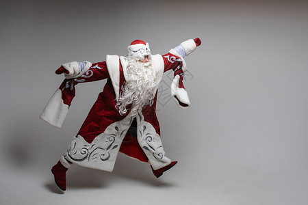 在灰色工作室背景上运行或跳跳圣诞老人 复制Xmas和新年假日广告设计空间背景图片
