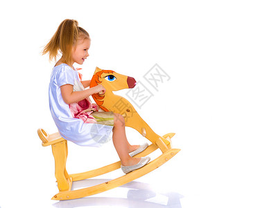 宝宝骑木马女孩在木马上摇摆 孩子 娱乐 时尚 运动 快乐的背景