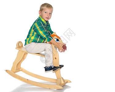宝宝骑木马一个小男孩骑着木马 喜悦 幼儿园 乐趣 工作室 家背景