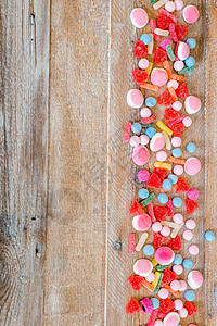 木制背景上各种糖果的种类 红色的 果冻 甜的 黄色的背景图片