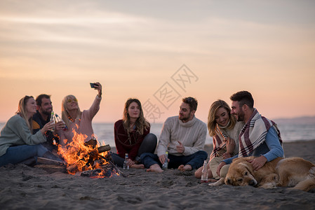 篝火剪影秋天在海滩玩得开心的朋友 女士 享受 女性 派对背景