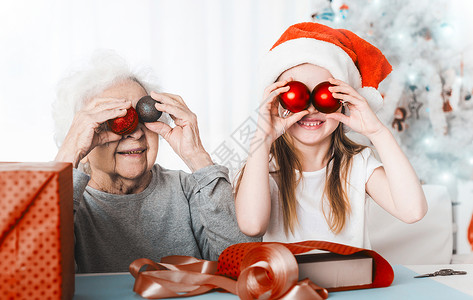 外孙女跟外婆拿着装饰球 礼物 剪刀 帮手 奶奶背景图片