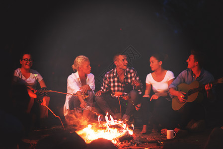 篝火音乐年轻朋友在营火周围放松 火焰 银行 篝火 夫妻 户外背景
