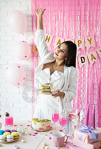 美丽的女人庆祝生日派对 拿着一块蛋糕做愿望的美人儿 假期 桌子背景