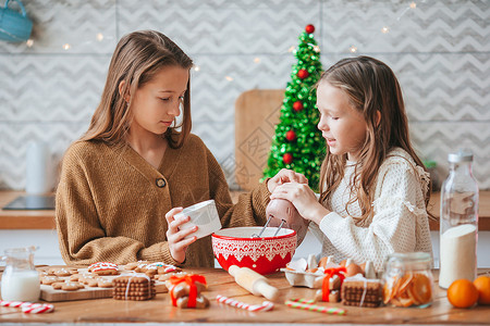牛轧饼干详情页小姑娘们在装饰的客厅壁炉里 做圣诞姜饼店 幸福 庆典背景