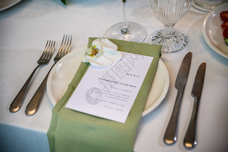 婚礼宴会 节日餐桌配有餐巾纸板 名卡 眼镜和餐具以及花朵安排和蜡烛的装饰 盘子 刀具环境高清图片素材