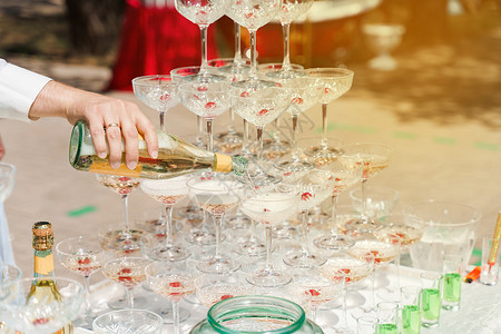 侍者将香槟倒入水晶杯中 在夏日倒在酒杯中的起泡酒 为商务人士提供餐饮服务 酒精 派对葡萄酒高清图片素材