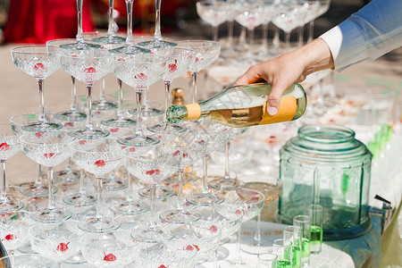 侍者将香槟倒入水晶杯中 在夏日倒在酒杯中的起泡酒 为商务人士提供餐饮服务 服务员 用餐葡萄酒高清图片素材