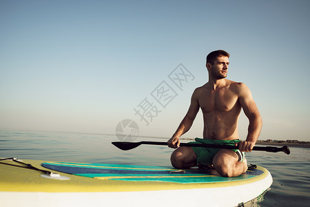 划冲浪板在湖边漂浮着的游艇上 年轻帅哥 锻炼 水 桨板背景