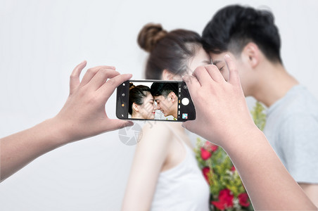 拍照的情侣手机摄影设计图片