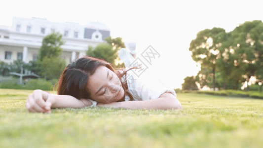 下蹲女孩夕阳下大学生躺在草地上GIF高清图片