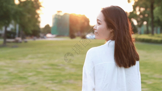 穿白衬衫的美女夕阳下甜美的学生GIF高清图片