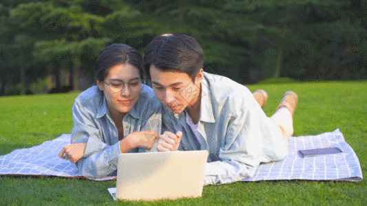 大学生在草地上使用电脑学习GIF图片