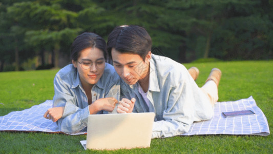 学生在学习大学生在草地上使用电脑学习GIF高清图片