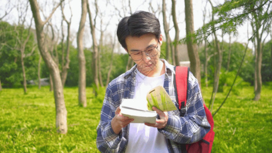 户外食物男青年户外阅读GIF高清图片