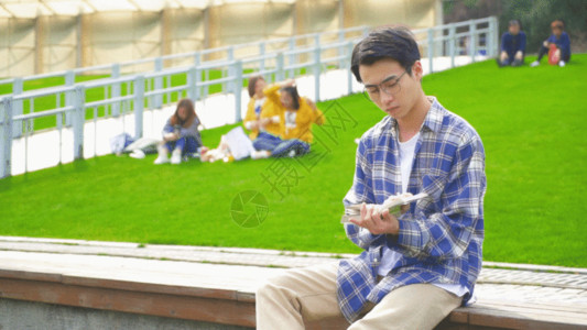 男青年喝水穿格子衫的男生阅读看书GIF高清图片
