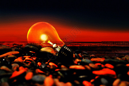 电子3C海边石头堆上发光的灯泡gif动图高清图片