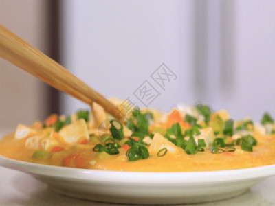 灯光下的饭桌实拍筷子夹豆腐GIF高清图片