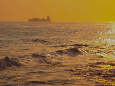 码头和小灯塔黄昏下的海上货轮和灯塔GIF高清图片