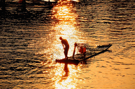 一叶舟夕阳余晖下的捕鱼人gif高清图片